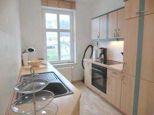 a kitchen with two glass bowls on the stove topinsula at Villa Melanie in Sassnitz