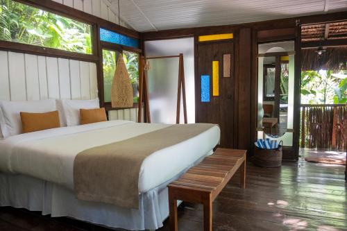 a bedroom with a large bed and a wooden floor at Casa Luz Paraty in Paraty