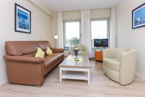 a living room with a couch and a table at Haus Hafenblick in Bensersiel