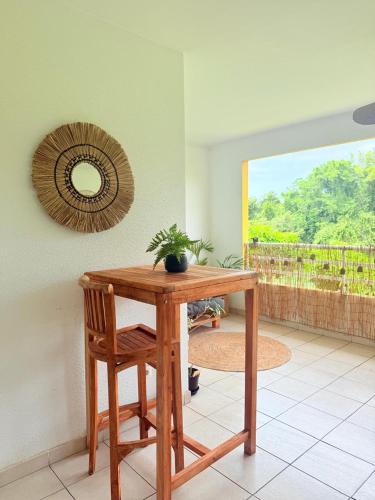 a table and a chair in a room with a mirror at Le Cocon de Convenance in Baie-Mahault