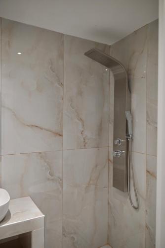 a shower with a glass door in a bathroom at Rastoni Apartments Skiathos in Troulos