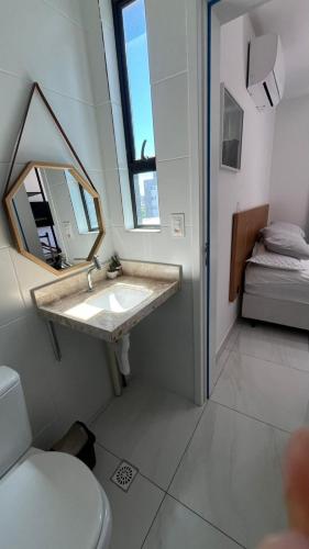 Un baño con lavabo, espejo y cama. en Flat Intermares, en Cabedelo