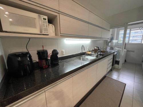 eine Küche mit einer Mikrowelle und einer Arbeitsplatte in der Unterkunft Nautilus Home Club próximo ao Beto Carrero e praias in Penha