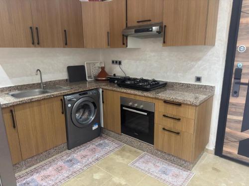 a kitchen with a washing machine and a sink at Bel appartement avec vue piscine, jardin & mer in Mohammedia