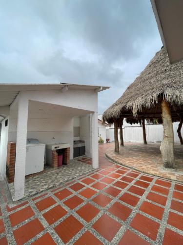 a house with a thatched roof and a patio at Baranoa House in Barranquilla