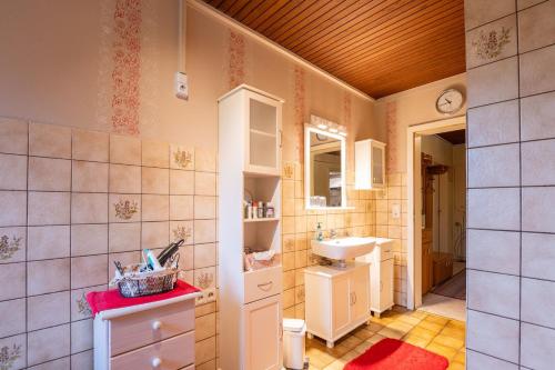 a bathroom with a sink and a mirror at Ferienwohnung Mientje, 35214 in Hesel