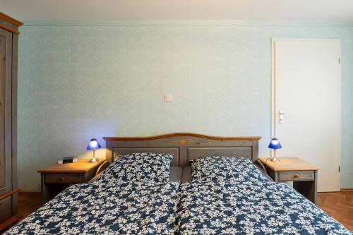 a bedroom with a bed and two nightstands with lamps at Ferienwohnung Mientje, 35214 in Hesel