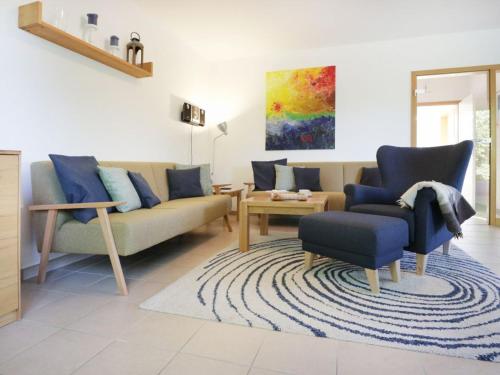 a living room with a couch and a chair at Löönboom in Groß Schwansee