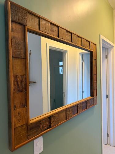 a mirror with a wooden frame on a wall at Apartamento em Ubatuba! A 100m da praia das Toninhas! in Ubatuba