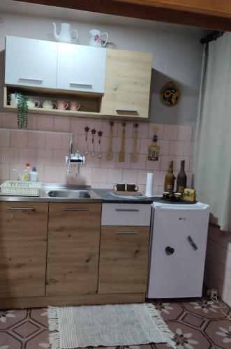 a kitchen with a sink and a white refrigerator at Apartman Sweet Dreams in Svrljig