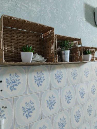 two baskets on a tiled wall with potted plants at Apartman Sweet Dreams in Svrljig