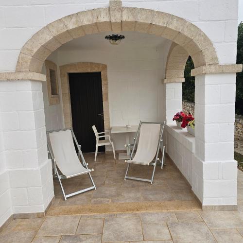 a patio with chairs and a table and an archway at AGRITURISMO Masseria Spetterrata in Cisternino
