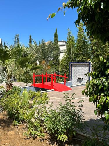 a red bench in the middle of a parking lot at Asilah Prestige -Vue Mer -Haut Standing - Piscines- Plage à 5 minute - Garage privée - Navette in Asilah