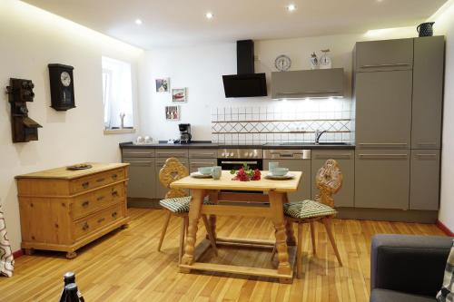 a kitchen with a table and chairs in a room at Ferienwohnungen Rosenhof in Tegernsee