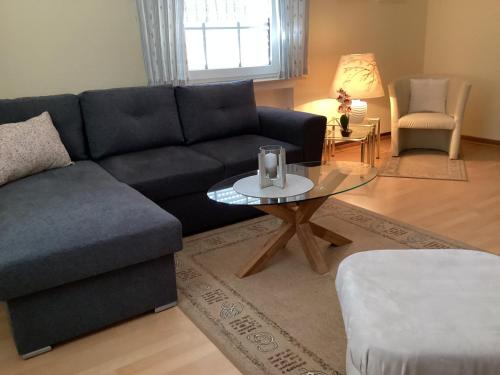 a living room with a blue couch and a table at Ferienwohnung Krapohl in Bad Harzburg