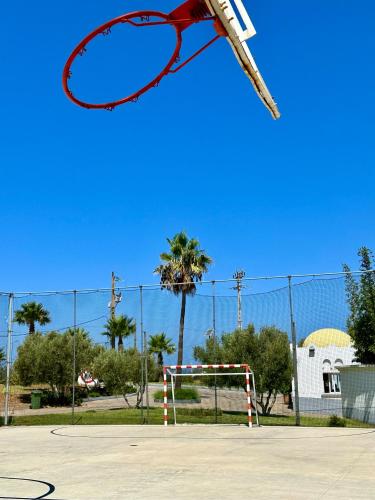 a racket is in the air over a basketball hoop at Asilah Prestige -Vue Mer -Haut Standing - Piscines- Plage à 5 minute - Garage privée - Navette in Asilah
