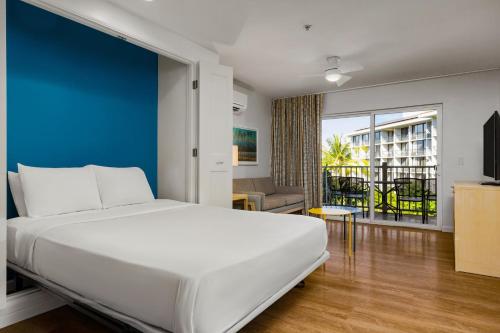 a bedroom with a white bed and a blue wall at WorldMark Kihei in Kihei