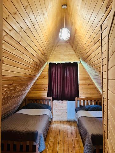 a room with two beds in a wooden attic at Borjomi Twins in Sadgeri