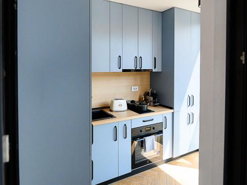 a kitchen with white cabinets and a stove top oven at Aparthotel Madonna Residence Petunilor in Craiova