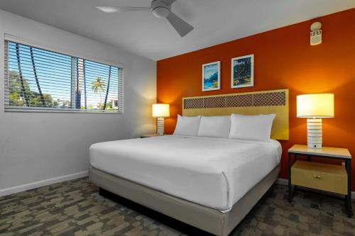a bedroom with a large white bed and two lamps at WorldMark Kihei in Kihei