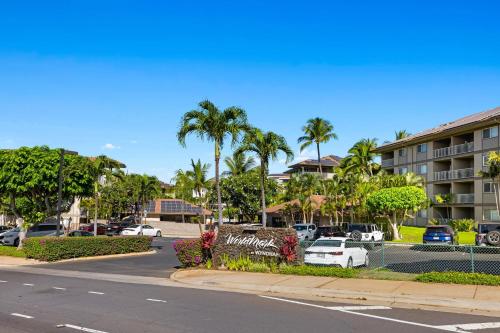 a parking lot with palm trees and a building at WorldMark Kihei in Kihei