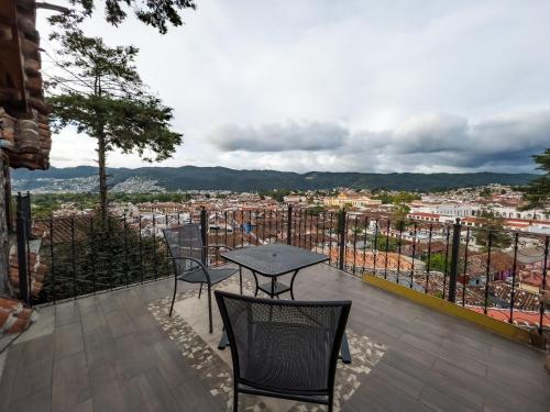 a table and chairs on a balcony with a view at Hotel Quinta los Morales in San Cristóbal de Las Casas