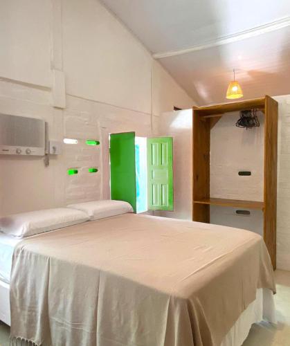 a bedroom with two beds and a green window at Estalagem Santo André in Santo André
