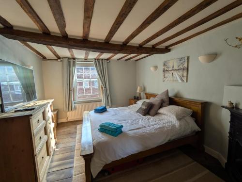 a bedroom with a bed and a wooden ceiling at Cosy Georgian Cottage in the Heart of Bewdley, Worcestershire in Bewdley