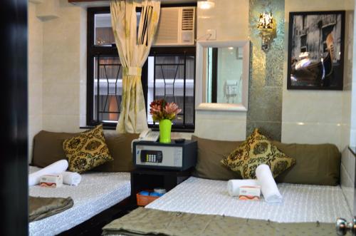 2 camas individuales en una habitación con ventana en Hostel Venus, en Hong Kong