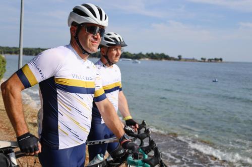 two men wearing helmets standing next to the water at Villa Badi in Umag
