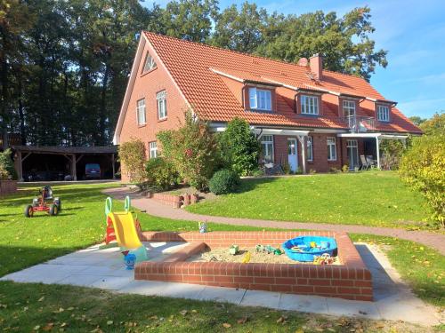 a house with a playground in front of a yard at Haus-Auetal in Bliedersdorf
