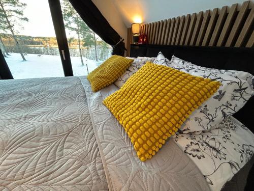 a bed with yellow pillows and a blanket on it at Mazurskie Wzgórze Nad Jeziorem Isąg in Pelnik