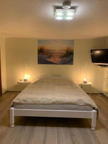 a bedroom with a bed and a flat screen tv at Ferienwohnung R Packmohr in Ueckeritz