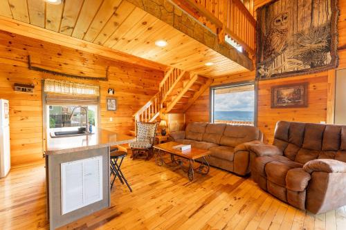 a living room with couches and a tv in a cabin at Hoot Owl with a private hot tub in Bryant