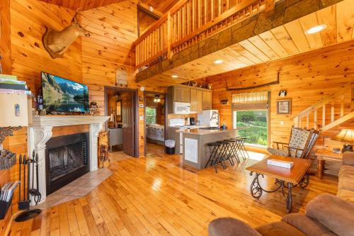 a living room with a fireplace in a log cabin at Hoot Owl with a private hot tub in Bryant