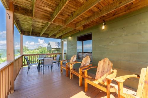 a porch with chairs and a table on it at Hoot Owl with a private hot tub in Bryant