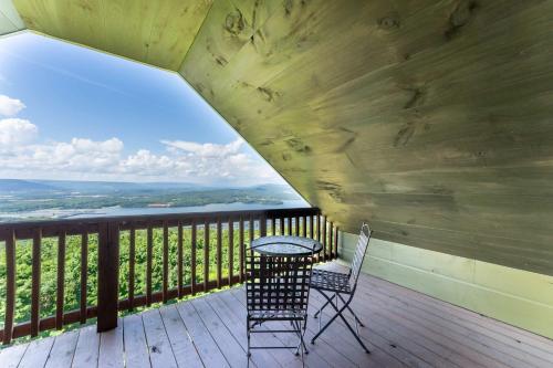 a table and chair on a deck with a view at Hoot Owl with a private hot tub in Bryant