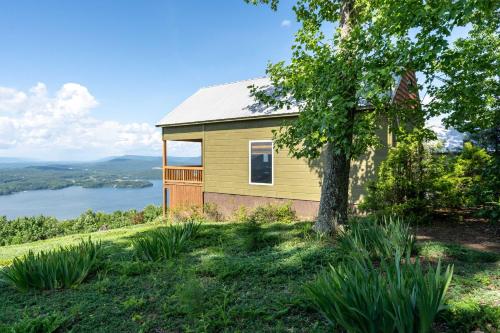 a house on top of a hill with a tree at Hoot Owl with a private hot tub in Bryant