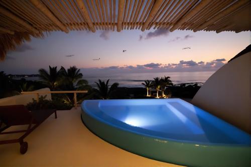 a blue tub on a balcony with the sunset at Punta Majahua by PRC Hospitality in La Majahua