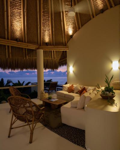 a living room with a couch and a table and chairs at Punta Majahua by PRC Hospitality in La Majahua