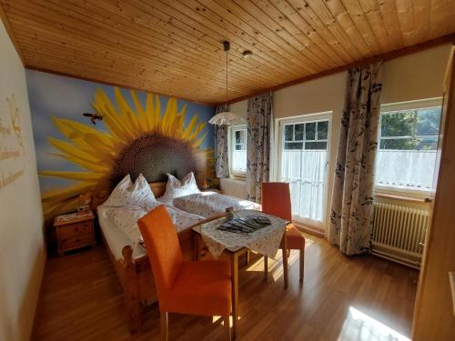a bedroom with a table and a sunflower painting on the wall at Ferienhaus Tschernitz in Pruggern
