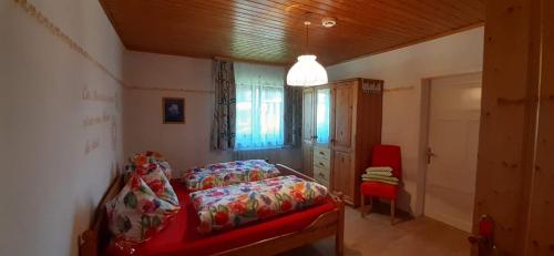 a bedroom with a red bed and a red chair at Ferienhaus Tschernitz in Pruggern