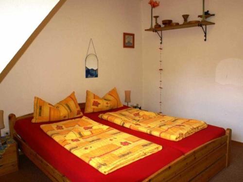 1 dormitorio con 2 camas con sábanas rojas y amarillas en Ferienwohnung Grueßing, 15014, en Leer