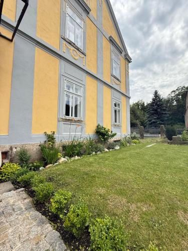 a yellow and gray house with a yard at CG Haensch in Großschönau