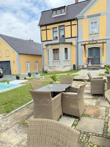 a patio with a table and chairs in front of a house at CG Haensch in Großschönau