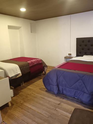 a room with two beds in a room at Auquis Hostel in Cusco