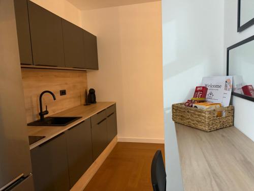 a kitchen with brown cabinets and a sink and a counter at Zs Apartment in Tuzla
