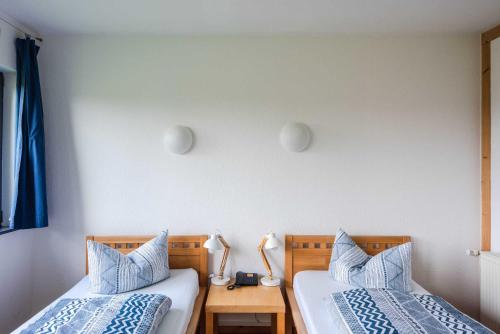 a bedroom with two beds with blue and white pillows at öko-hotel in Neustrelitz
