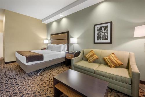 a hotel room with a bed and a couch at Best Western Plus College Park Hotel in College Park