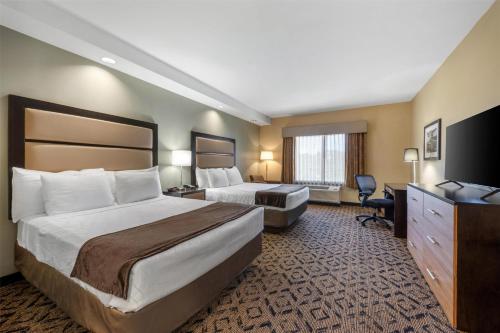 a hotel room with two beds and a television at Best Western Plus College Park Hotel in College Park